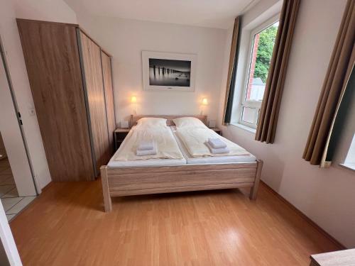 um quarto com uma cama num quarto com uma janela em Nordland Appartements - Wohnung Sylt em Wyk auf Föhr