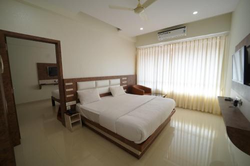 um quarto com uma grande cama branca e um espelho em Bhramari Nest em Subrahmanya