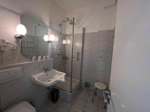 La salle de bains est pourvue d'un lavabo et d'une douche en verre. dans l'établissement Nordland Appartements - Wohnung Sylt, à Wyk auf Föhr