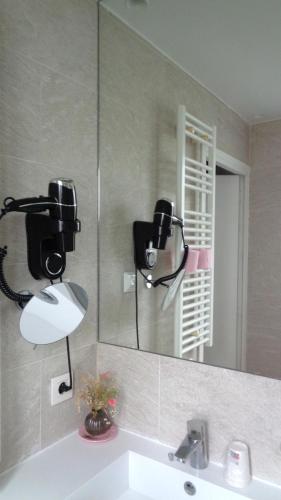 a bathroom with two cameras on a mirror and a sink at Hotel Royal Phare in Paris