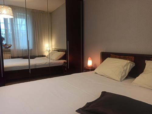 sypialnia z 2 łóżkami i lustrem w obiekcie Apartament Kościuszki w Kielcach