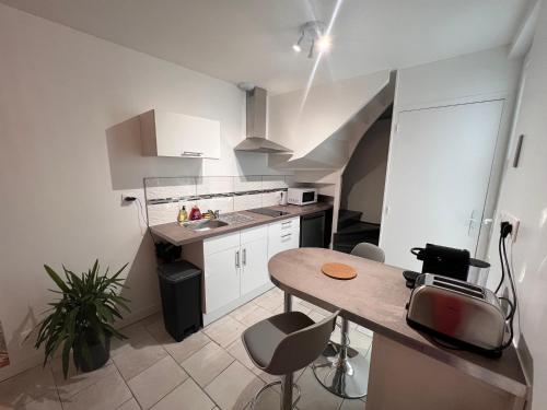 a small white kitchen with a table and chairs at YellowHouse - CosyHouseByJanna in Châtellerault