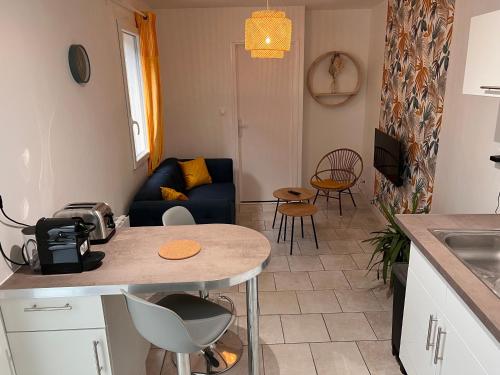 uma cozinha e sala de estar com uma mesa e um sofá em YellowHouse - Teleworking- Wifi - CosyHouseByJanna em Châtellerault