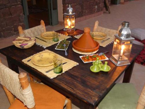 a wooden table with food and lights on it at Issouganes N Toubkal Maison d hôtes in Oussertek