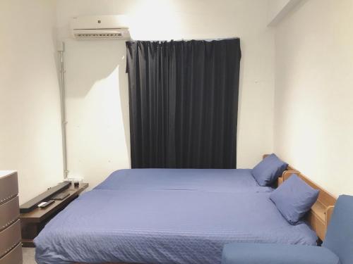 a bedroom with a large bed and a curtain at OAK Yasaka / Vacation STAY 477 in Osaka