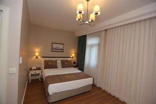 a bedroom with a large bed and a chandelier at HaciBayramHotel in Istanbul