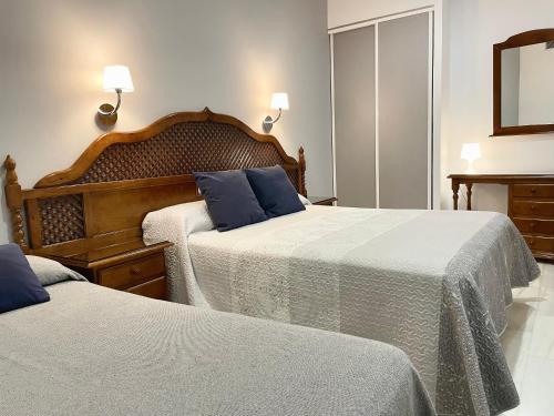 a bedroom with two beds and a mirror at Los Omeyas in Córdoba