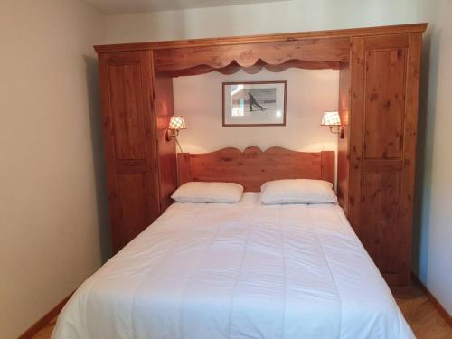 une chambre avec un grand lit avec une tête de lit en bois dans l'établissement Luxueux appart 3 chambres, piscine chauffée, sauna, ski aux pieds, wifi, animaux admis - FR-1-322-456, aux Orres