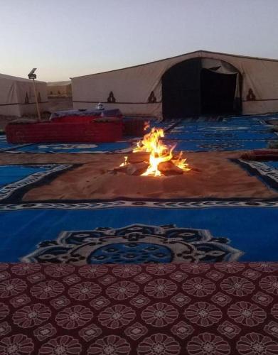 a tent with a fire in the middle of a room at Bivouac Draa in Zagora