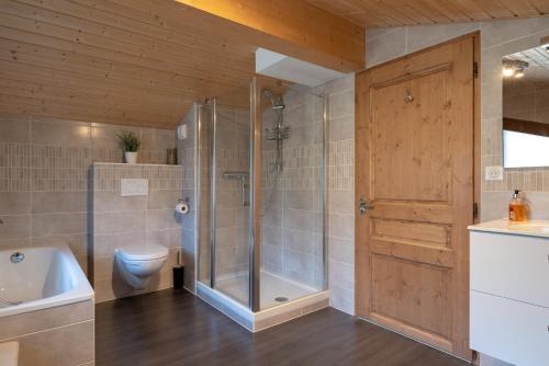 une salle de bain avec une douche, des toilettes et un lavabo dans l'établissement Apartment La Colombe, aux Gets