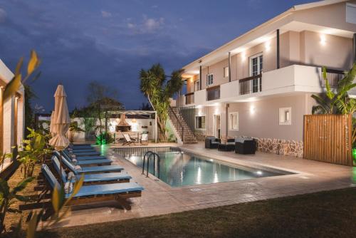 a villa with a swimming pool at night at Bruma Luxury Residence in Mouzákion