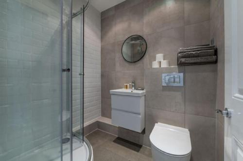 a bathroom with a toilet and a glass shower at 2 Bedroom - Tower Bridge - London City by Prime London Stays M-8 in London