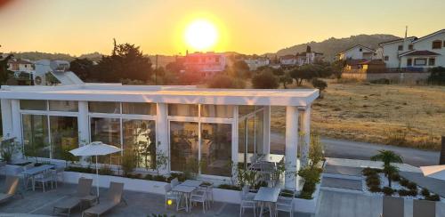 a building with the sun setting in the background at Nama Retreat in Pastida