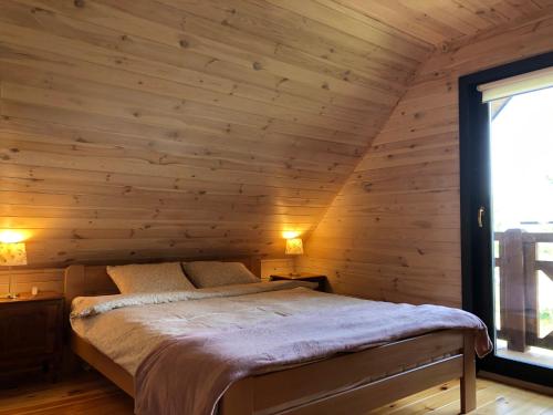 1 dormitorio con 1 cama en una cabaña de madera en Na Tałandy, en Szczebrzeszyn
