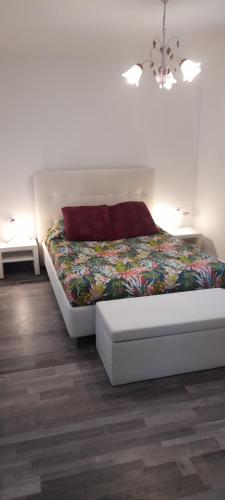 - une chambre blanche avec un lit et une couverture colorée dans l'établissement La Grangette du Mas, à Chassiers