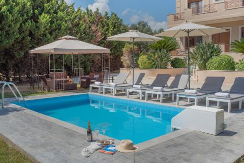 basen z leżakami i parasolami obok domu w obiekcie Emma's Luxury Villa w mieście Pastida