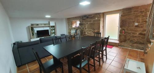 a dining room with a table and chairs and a couch at Casa Pinto - AL in Valença