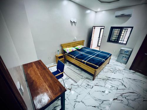 a bedroom with a bed and a desk and a table at Les Résidences de Gorée in Cotonou