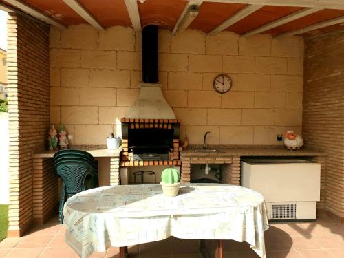 eine Außenküche mit einem Tisch und einem Herd in der Unterkunft Villa Preciosa Piscina Climatizada in Mazarrón