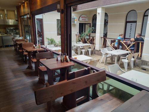 an empty restaurant with wooden tables and chairs at Complex Friends in Pleven