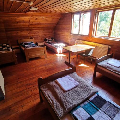 a living room with a wooden cabin with a table and chairs at SzSM Hadle Szklarskie in Hadle Szklarskie