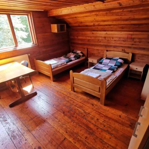 a room with two beds in a log cabin at SzSM Hadle Szklarskie in Hadle Szklarskie