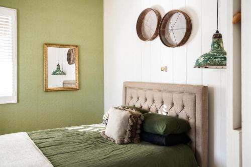 um quarto com uma cama com paredes verdes e espelhos em Mill Cottage em Tenterfield