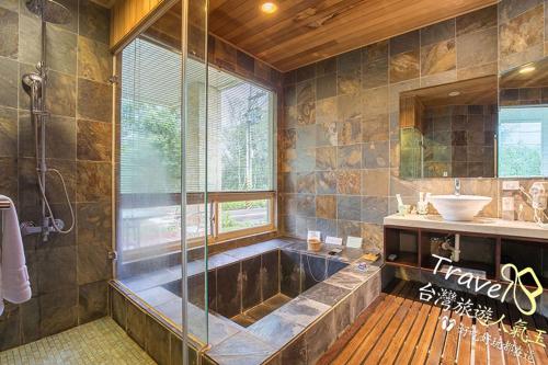 a large bathroom with a tub and a sink at Tree Lake B&B Hualien in Shuhu