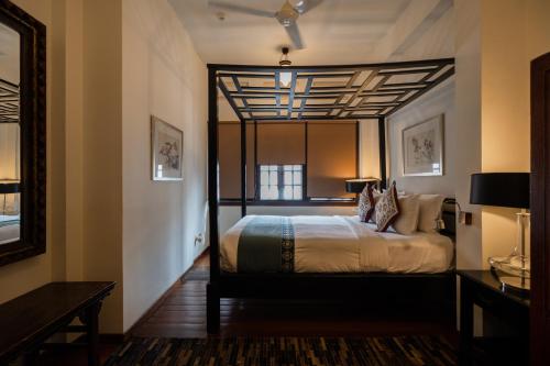 a bedroom with a large bed with a ceiling at Hotel Penaga in George Town