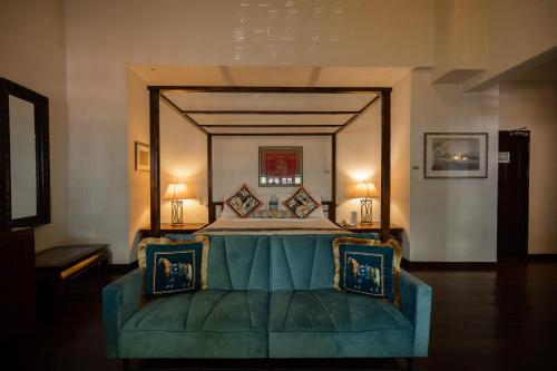 a bedroom with a large bed with a green couch at Hotel Penaga in George Town