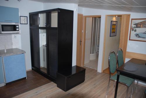 a black refrigerator in a kitchen with a table and chairs at Willa pod piórem in Szczyrk