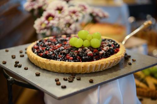 a pie with grapes and blackberries on a table at Logos hotel in Yad Hashmona in Yad Hashmona