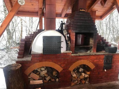 an outdoor brick oven with a pile of wood at Cabana Sweetlife in Rimetea