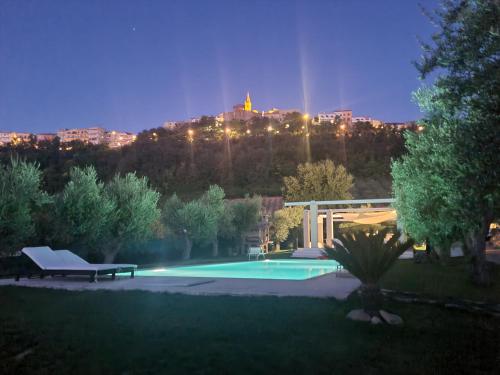 a swimming pool in a yard with a city in the background at Rocky House in Ripa Teatina