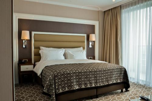 a bedroom with a large bed and a large window at ALUSSO THERMAL HOTEL SPA in Afyon