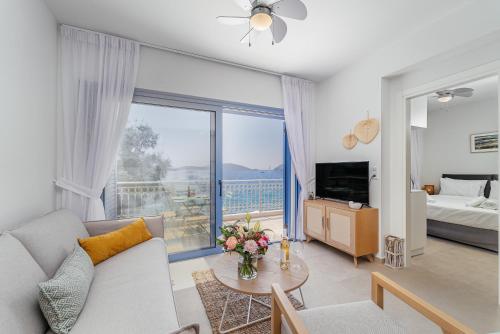 a living room with a couch and a large window at Greek Beach House Complex B4 in Nydri