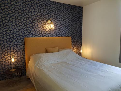a bedroom with a bed and a wall covered in wallpaper at COTE CIEL - CANCALE - GITE STANDING - PROCHE CENTRE ET PORT in Cancale