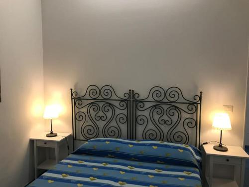 a bedroom with a bed with two nightstands and two lamps at I datteri Bilocale ristrutturato a meno di 300 mt dal mare in Gaeta