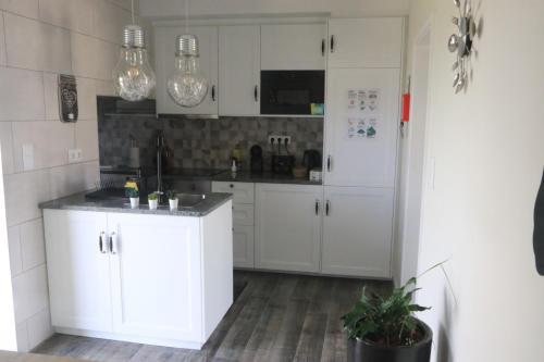 a kitchen with white cabinets and a white refrigerator at Casinha da Alegria in Nordeste