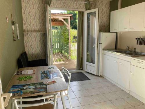a kitchen with a table and a door to a yard at Appartement Vert, Compreignac in Compreignac