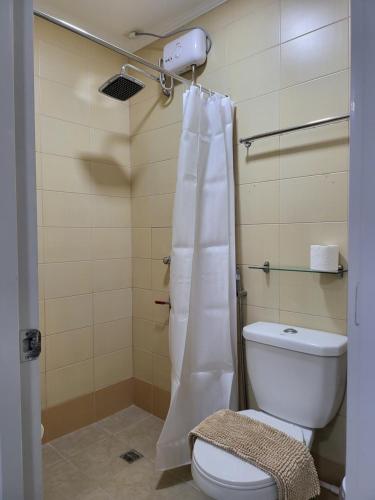 ein Bad mit einem WC und einem Duschvorhang in der Unterkunft Rooms R Us - Evangelista in Manila