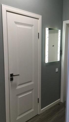 a white door in a room with a mirror at Квартира в центре Нур-Султана in Astana