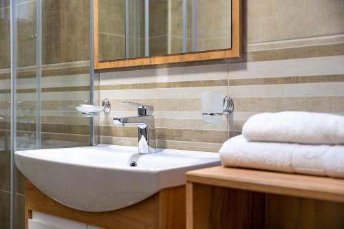 a bathroom with a sink and a mirror and towels at Monix Palace Zlatibor in Zlatibor