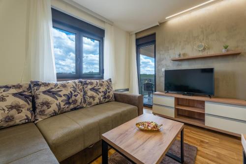 a living room with a couch and a flat screen tv at Monix Palace Zlatibor in Zlatibor