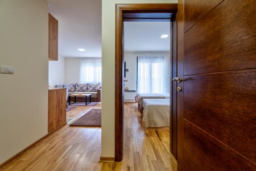 a bedroom with a bed and a wooden door at Monix Palace Zlatibor in Zlatibor
