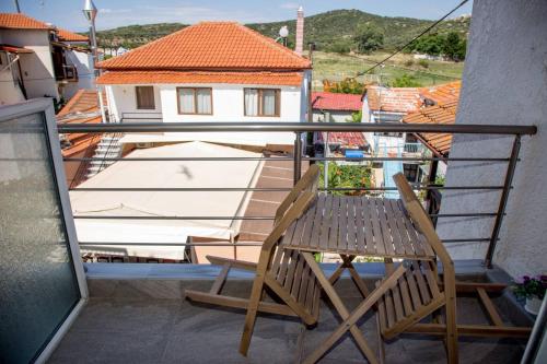 una silla de madera sentada en un balcón con una casa en elenamou seaview rooms en Amoliani