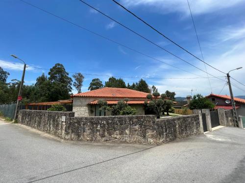 a stone wall in front of a house at O Celeiros in Freixo