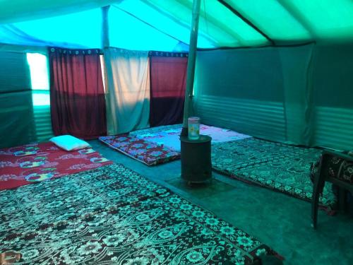 City Escape Camps and Cafe Kheerganga في Kheerganga: خيمة فيها سريرين وطاولة فيها