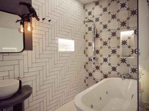 baño con bañera y pared de azulejos en La Encantada, en Elche de la Sierra