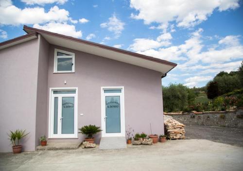 a white house with windows and potted plants at Agriturismo Il Borgo in Passo di Mirabella